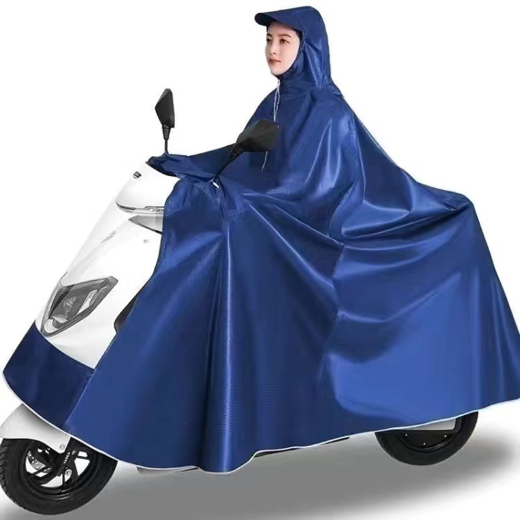 レインコート電気自動車のレインコートを大きくして、オートバイの二人のシングル男性女性が豪雨防止全身に足を隠します。|undefined