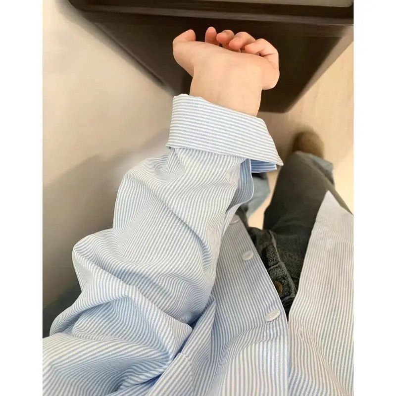 春と秋のストライプのシャツの女性の中には、日本のゆったりとした長袖のシャツを重ねて着ています。|undefined