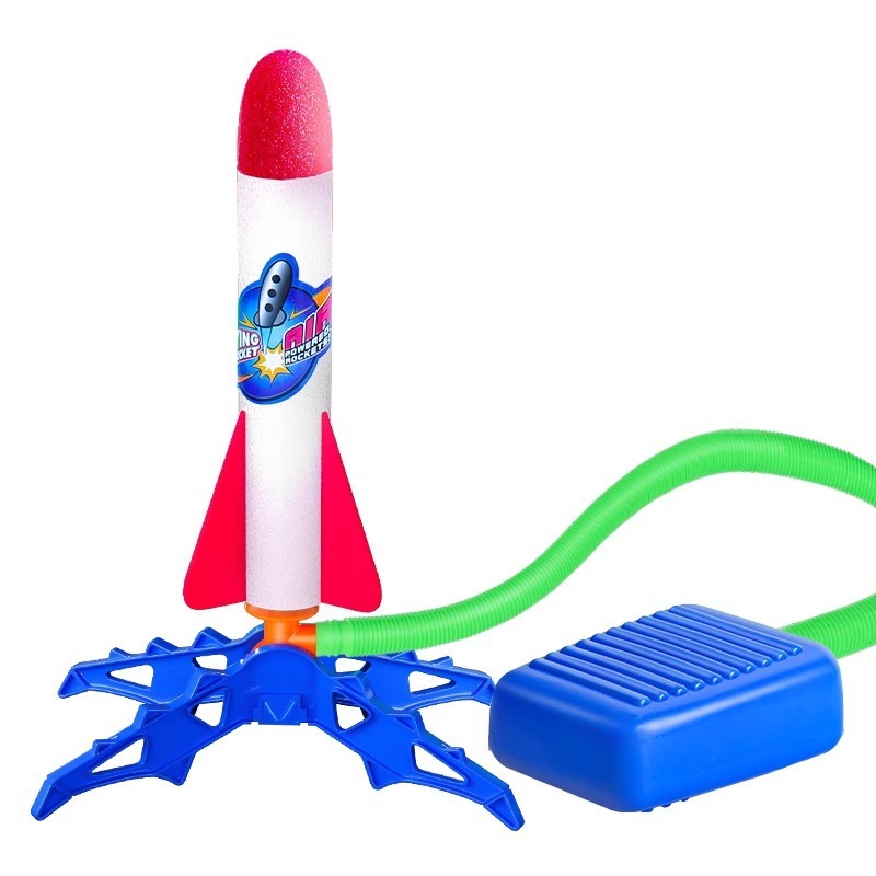 子供の足は天を突くロケットの発射筒の屋外の足を踏んで空を飛ぶおもちゃの大砲の足踏み式の発射機の男の子を踏みます。|undefined