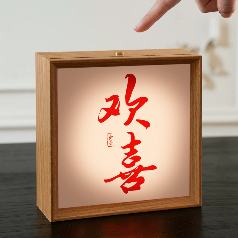 結婚装飾は暖かい夜の明かりのベッドの上に書道の喜字の結婚部屋の寝室の新しい部屋の新婚プレゼントを並べます。|undefined