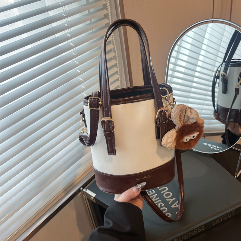 2025 nueva moda extranjera coreana bolso de cubo de mano simple ocio empalme viaje mochila de hombro para mujeres