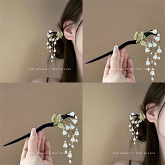 清新な白いすずらんの歩はかんざしの高級感の国風のチャイナドレスを揺らします。