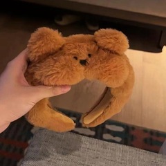 かわいいぬいぐるみの熊の手はカチューシャの髪飾りをします。