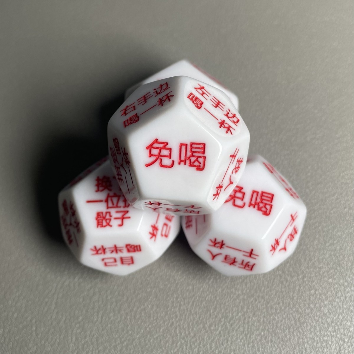 12-sided engraved dice with red characters on a white background, a fun drinking game prop for bars