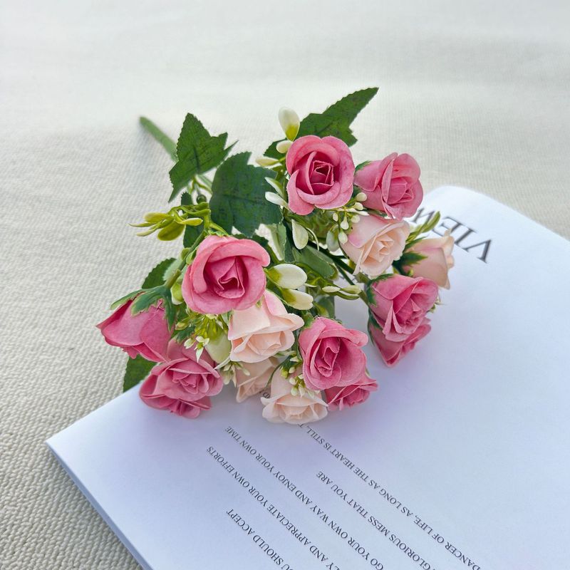 模造花ミニバラは花を手にして家にいる結婚式の室内客間の装飾に造花を飾っている|undefined
