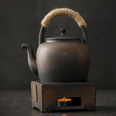 日本式のレトロな温茶炉の小さいストーブのろうそくはお茶の台の保温のお茶を温める器を煮てお茶のストーブのロゴを焼きます。