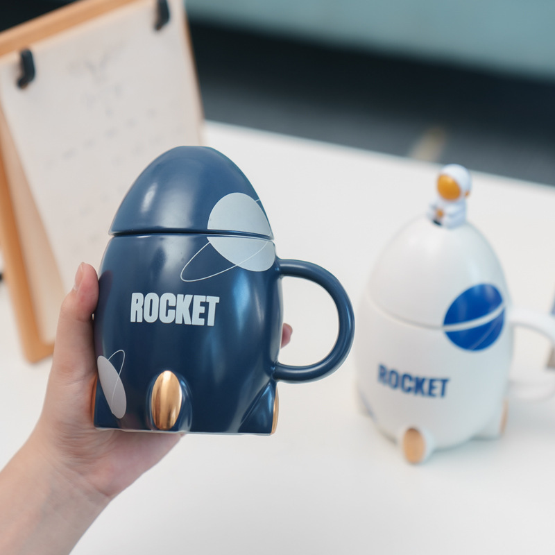 Taza de cerámica de cohete de dibujos animados Taza creativa con cuchara de tapa Taza de café de leche de dibujos animados lindo ins de alto valor