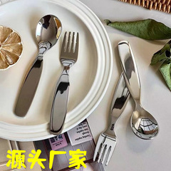 ステンレスの子供のスプーンのフォークの食器のかわいい子供の赤ちゃんは食事をしてスープを飲みます。