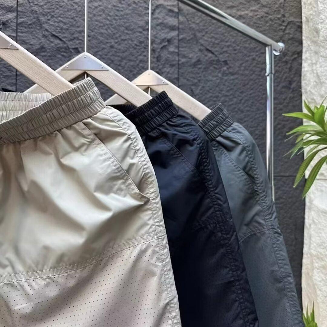 Verano nuevo estilo de secado rápido suelto tendencia casual perforado pantalones de cinco puntos moda masculina pantalones deportivos fríos y transpirables