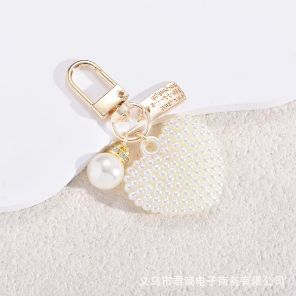 Cross-border creative pearl hollow heart-shaped Bluetooth earphone case bag accessory, new pearl alloy keychain pendant