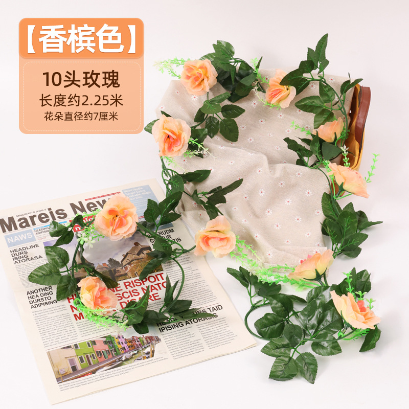 Simulación de flores falsas rosas de caña colgando la pared tubería de drenaje envuelta hoja verde que cubre la parte superior de la decoración de boda de plástico