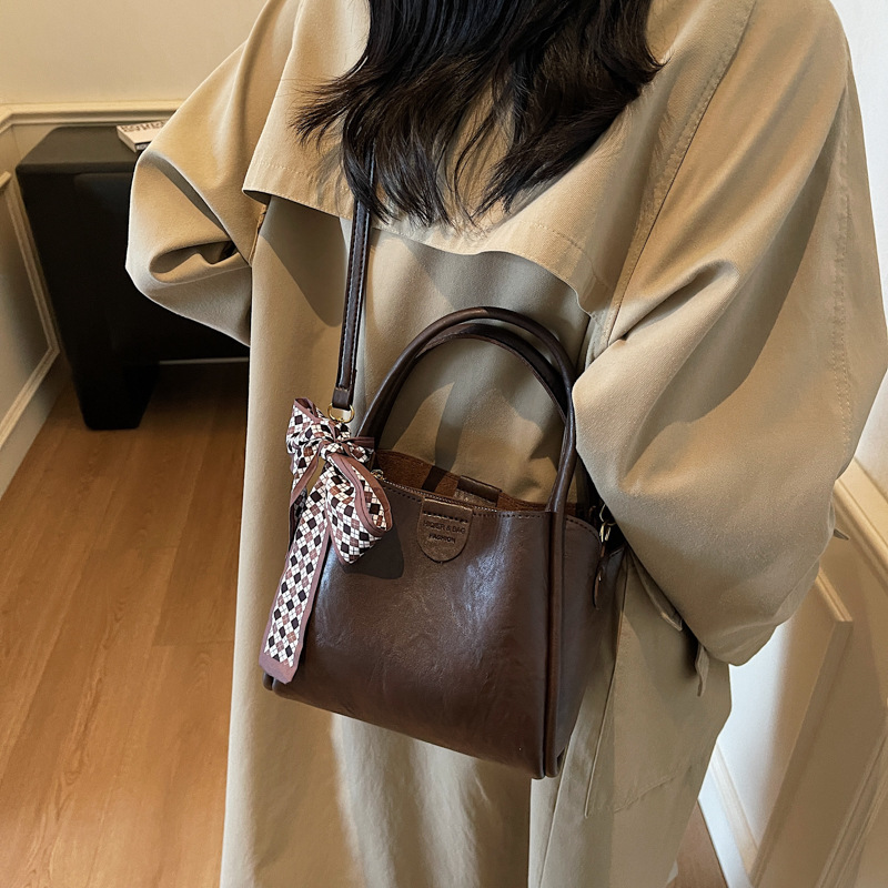 Bagos de transporte retro de estilo extranjero otoño y invierno 2025, nueva moda de un solo hombro, bolsas de cubo simples