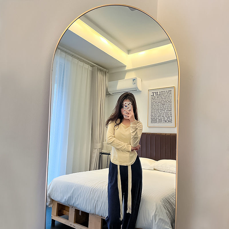 El espejo de vestir de la tienda de ropa es delgado y hermoso. Espejo de vestir súper blanco. Espejo de piso arqueado para tienda de ropa para mujeres.