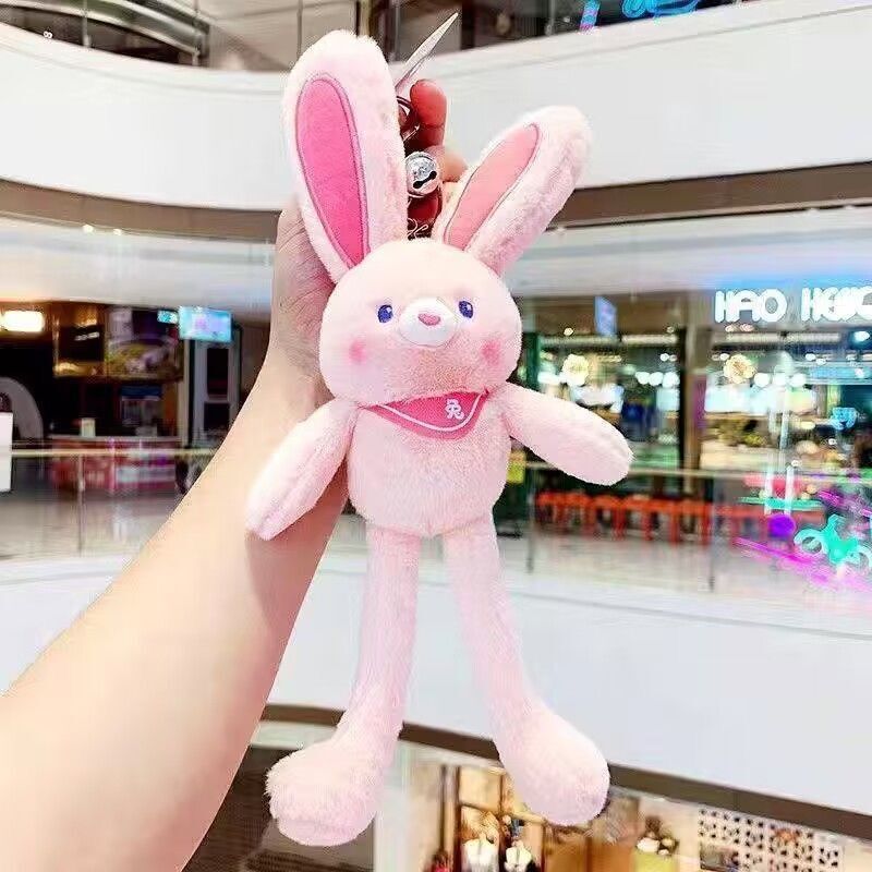 ネットの赤い耳のウサギはウサギの鍵を引いてぬいぐるみのかばんのペンダントを掛けて女の子にプレゼントします。|undefined