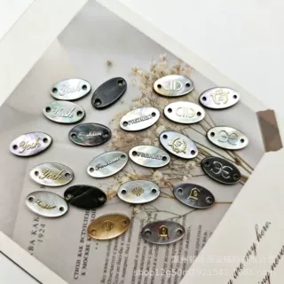 天然黑蝶贝壳椭圆双孔吊牌 烫金字母图案 服装领标装饰辅料配件
