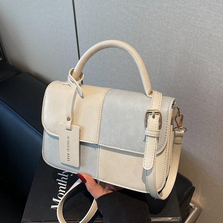 Bolso de mano coreano de color para mujeres 2025 nuevo nicho de textura universal bolso de hombro simple mochila casual