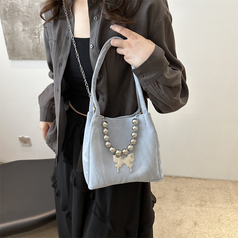 Alta sensación de lujo ligero bolso de cubo axilar 2024 verano nuevo estilo de moda arco de cuentas cadena de hombro mochila