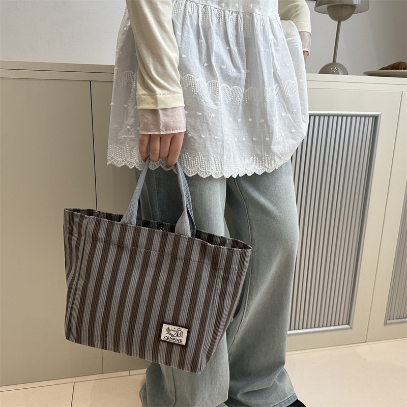 Bolso tote de tela a rayas de estilo europeo y americano, nuevo bolso pequeño de moda, bolso femenino portátil, bolso de almuerzo de mano, bolso de bocadillos