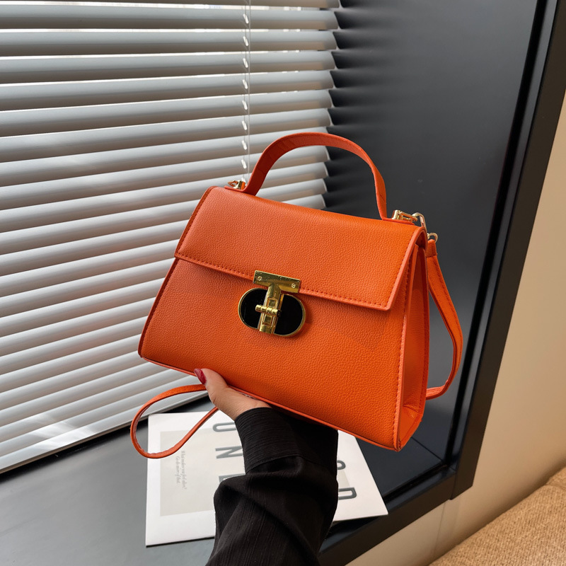 Bolsos de diseño de nicho a la moda para mujer este año: nuevos bolsos cuadrados pequeños con un moderno diseño de cierre, disponibles como bolsos de hombro o bandoleras en colores sólidos con una textura premium.