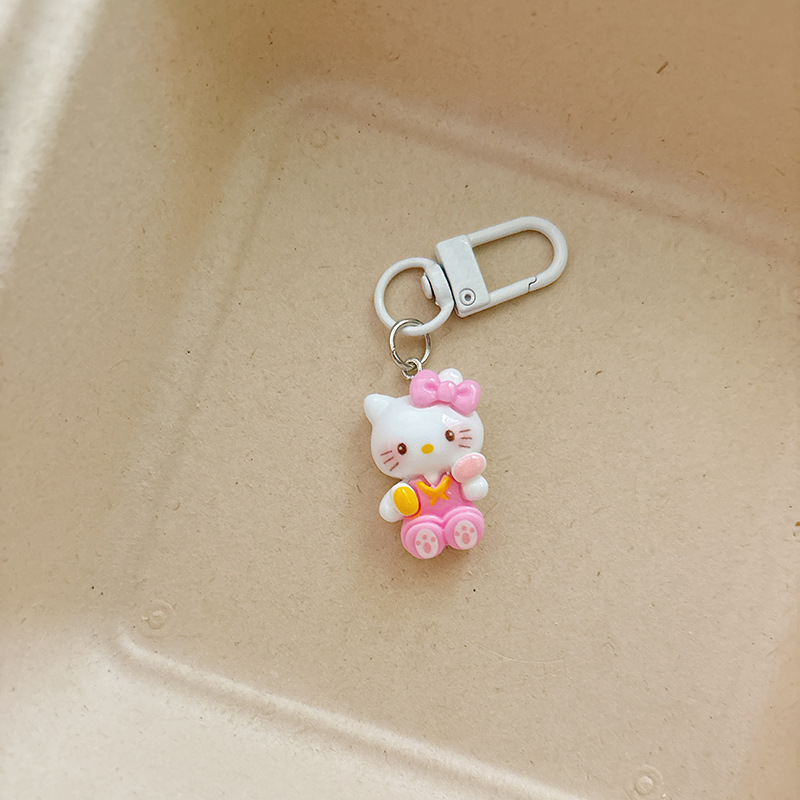 アニメの楽しい子猫のキーホルダーがかわいいkt猫のバッグに飾られた学生のかばんには、親友のプレゼントが飾られている|undefined