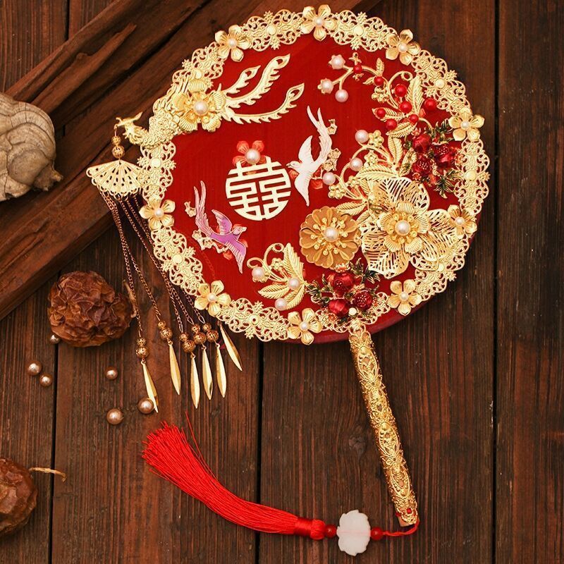 中国式の結婚式の秀禾の顔の団扇の震え音の赤い本の新婦の結婚する手は花の古風をささげて結婚します。|undefined