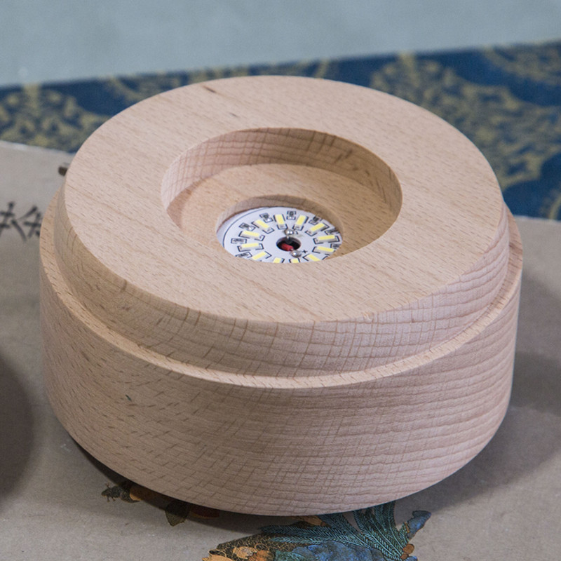 Bola de cristal giratoria caja de música LED base luminosa luz de la noche de dibujos animados pequeña base de la decoración