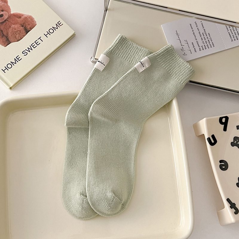 Otoño e invierno Nuevos calcetines de algodón absorbentes de sudor calcetines de pila serie de crema para mujer estilo ins Corea del Sur etiqueta de tela calcetines de media pantorrilla moda