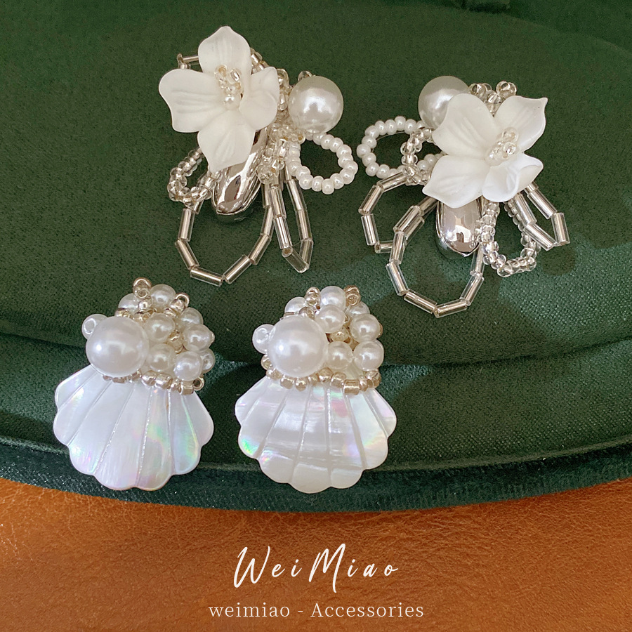 Agujas de plata flores gota de agua perlas personalidad exquisita nicho temperamento pendientes ligeros de lujo alta sensación de pendientes mujeres al por mayor