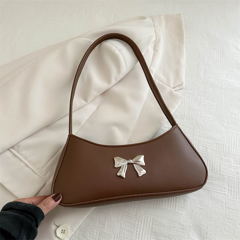 Bolsos axilales de alta textura 2024 verano nuevo diseño de moda francesa temperamento simple arco bolso de hombro