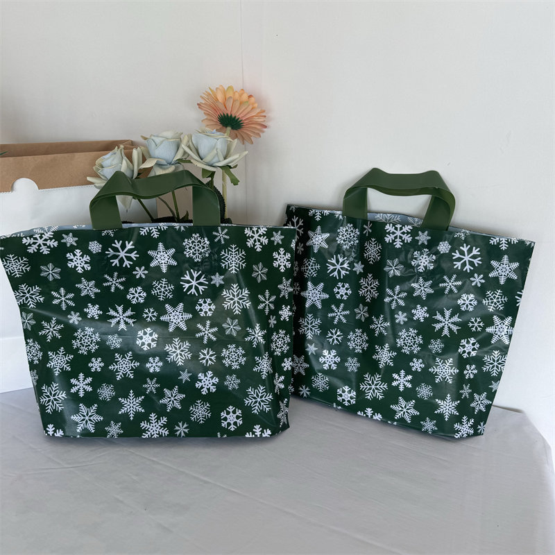 クリスマスの祝日の緑の厚いプラスチックの贈り物の服の店は手提げの袋の包装で厚いショッピングを包装して祝い事を包装します。|undefined