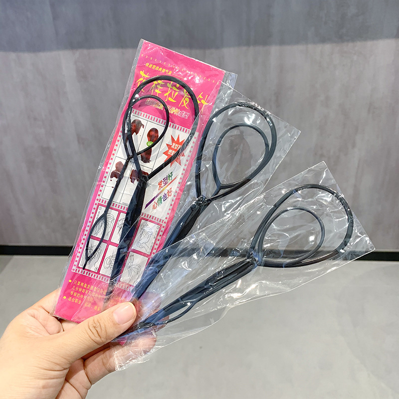 子供の髪の神器の髪を編む針の女の子は髪の毛を取り出して髪を着ます。|undefined