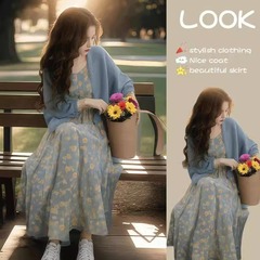 優しい風の春に女性の新しいファッションの軽熟風のカーディガンを着て、街の花のストラップのワンピースを揚げます。