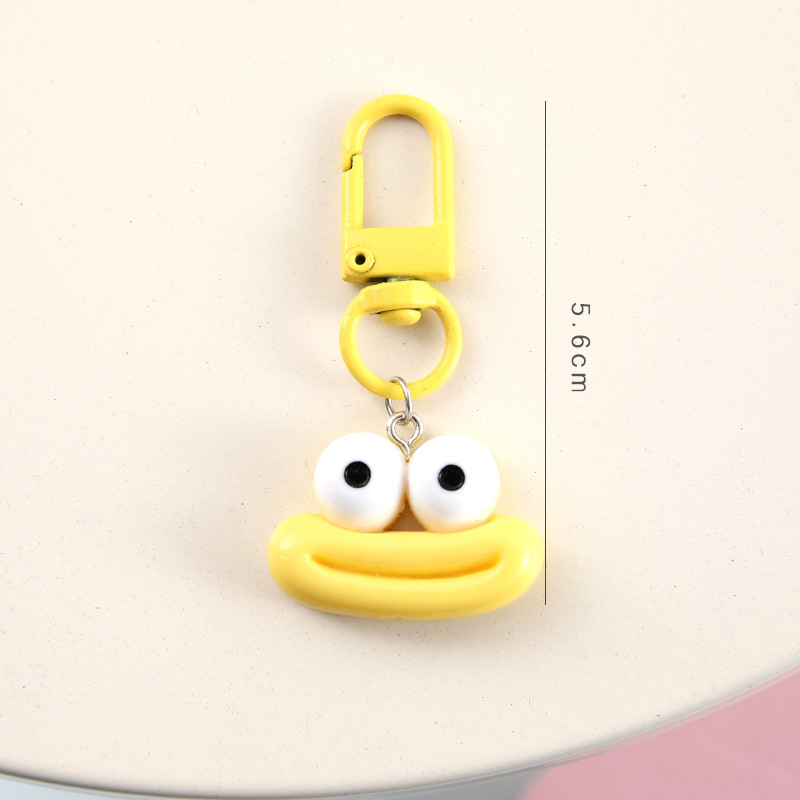 かわいいアニメの大きな口のキーホルダーは学生のカバンを飾っています。