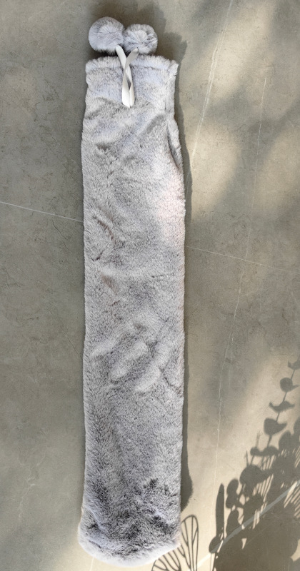 긴 회색 수국 천 커버에 뜨거운 물병이 들어있습니다.