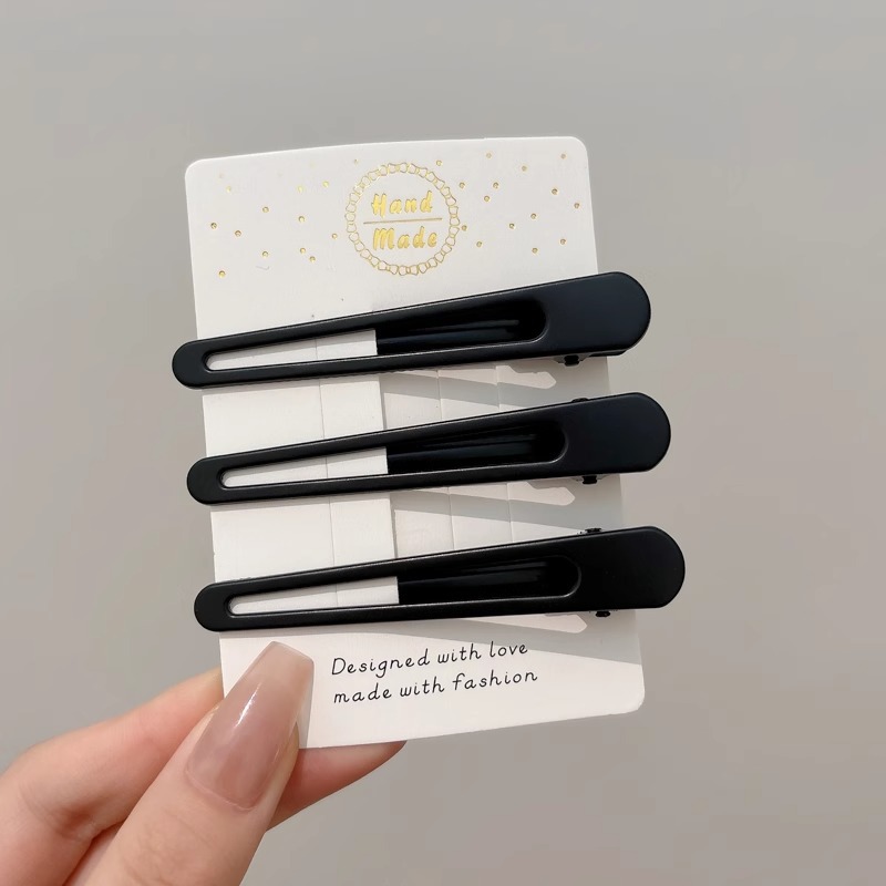 Clipper de cabello de metal negro de alto nivel, frente lateral de la mujer, cabello roto, boca de pato, tocado, clipper para el cabello