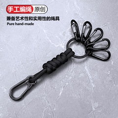 クロスボーダーのオリジナルデザインの新しいキーホルダーの個性的な手編みの傘のひもの自動車の鍵のボタンのフックは掛け縄を防ぎます。