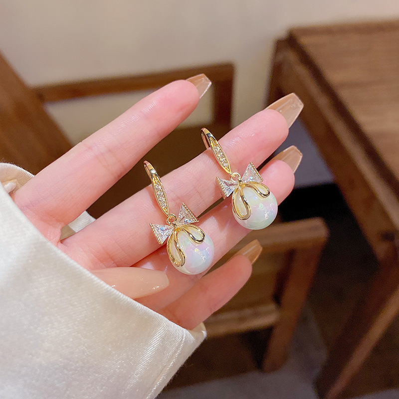 S925 aguja de plata Luz de lujo nicho pendientes de perlas de alto grado versátil elegante exquisito diamante incrustado arco pendientes