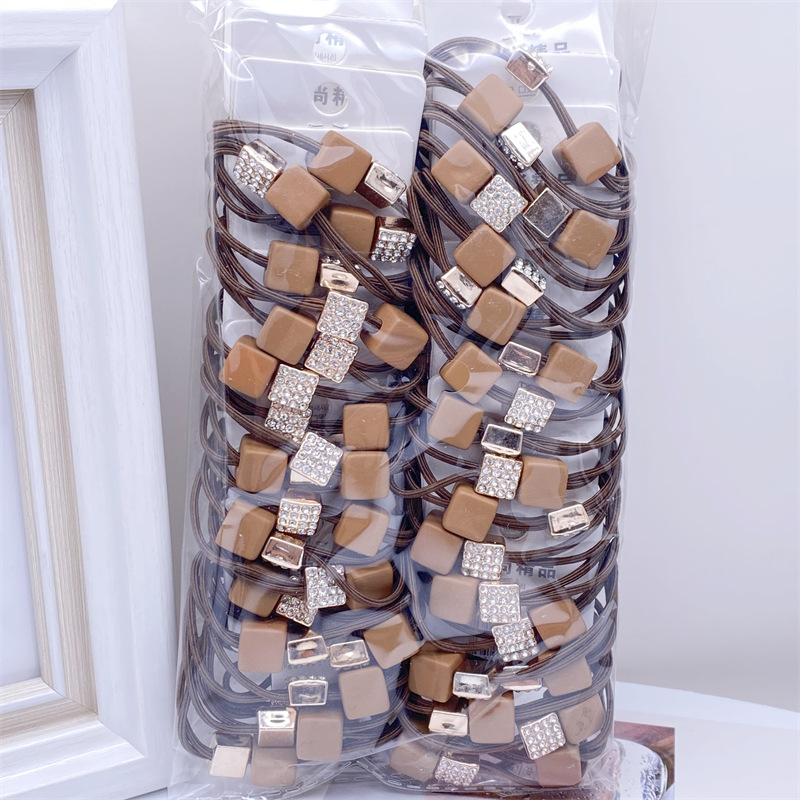 Etiqueta de estilo coreano accesorios para el cabello para niños Perla pequeña pajarita cuerda de pelo chica estudiante cabeza cuerda banda de goma dos yuanes suministro de la tienda