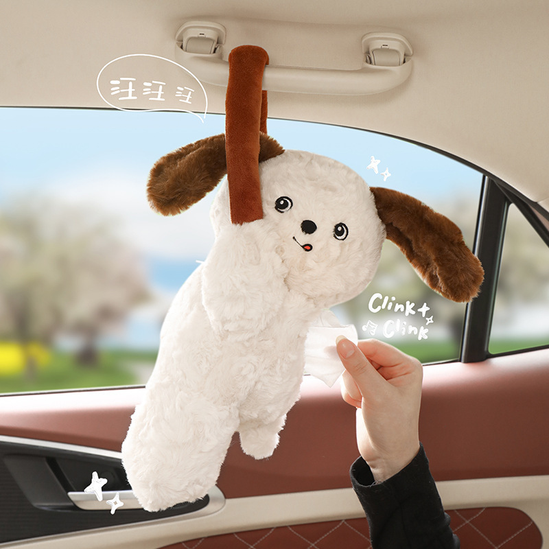 車のティッシュの箱のかわいい子犬のぬいぐるみがうつぶせになります。|undefined