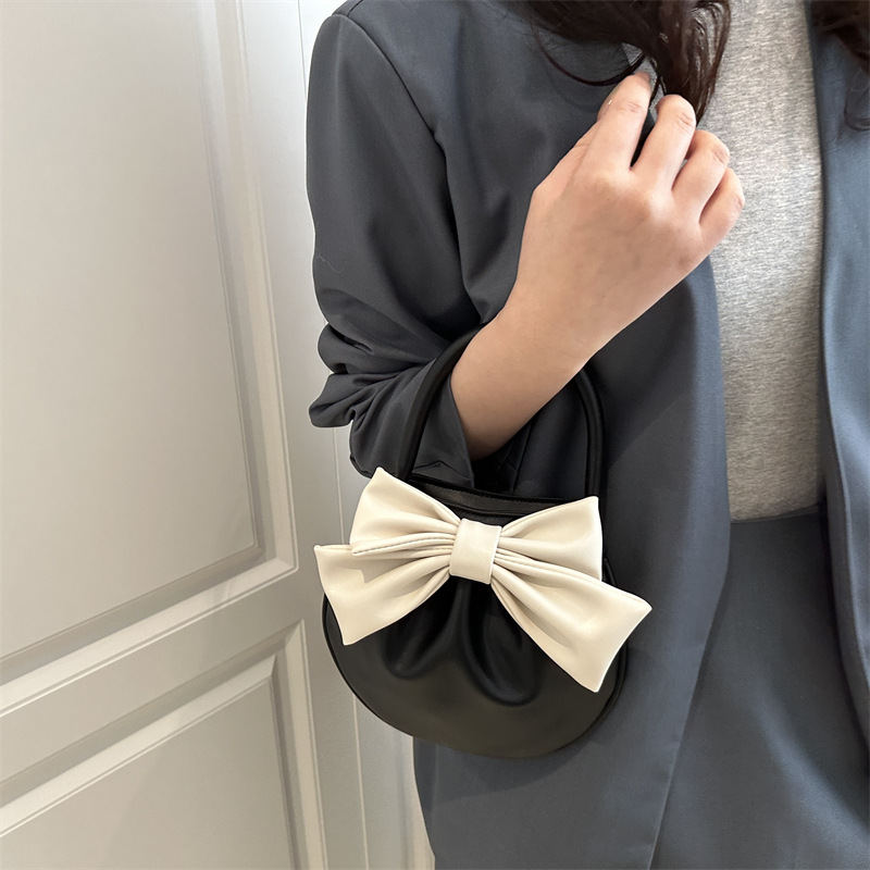 2025 primavera y verano nuevo nicho de diseño de arco bolsos portátiles de mujer alta sensación pequeña bolsa redonda roja