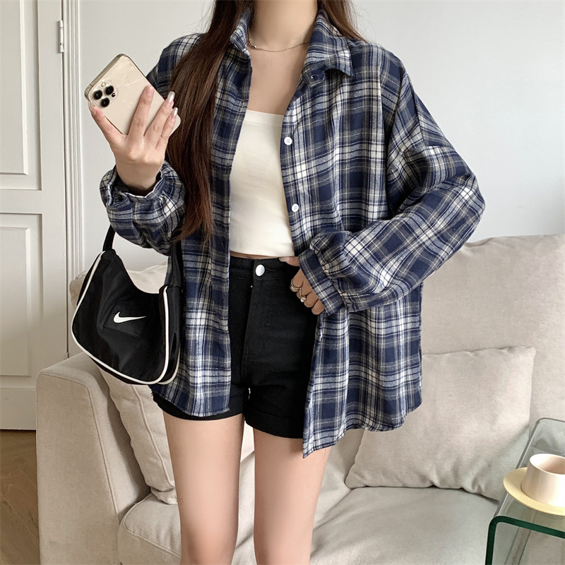 実際に日韓のレトロな格子のシャツの女性の外で長袖のシャツのコートの上着のゆったりしている設計感の長袖のコートをたたきます。