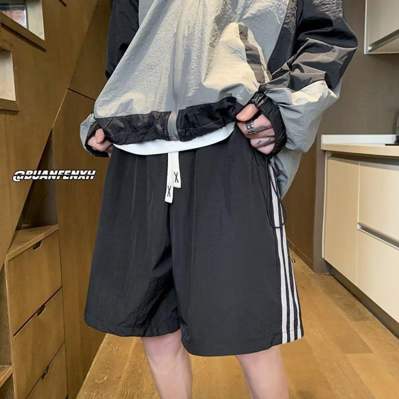 Pantalones cortos de secado rápido estadounidenses para hombres 2025 nuevos pantalones casuales de verano a rayas de cinco puntos tendencia deportiva suelta