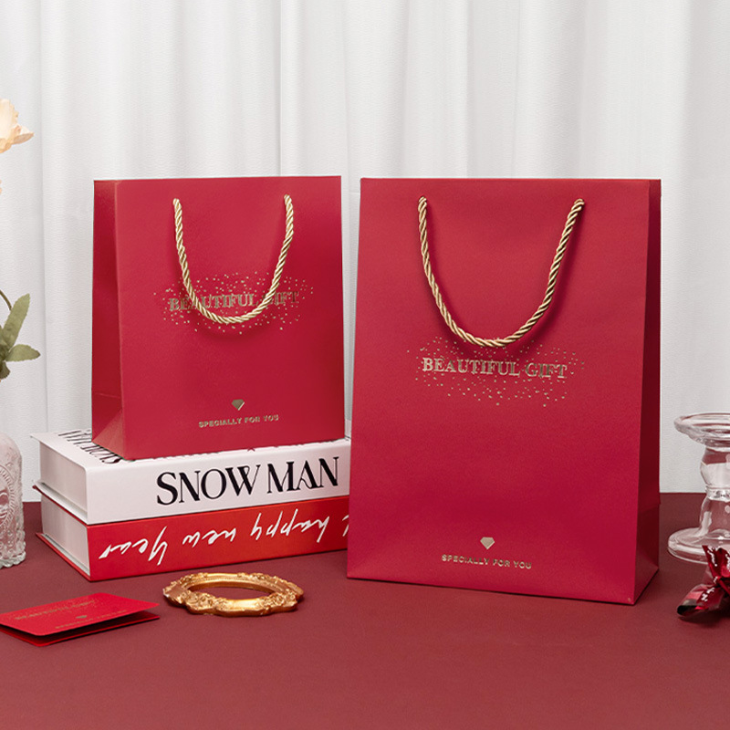 Spot bolsa de regalo roja bolsa de embalaje festiva de boda tarjeta roja papel bronceado bolsa de mano regalo fábrica de bolsas de papel al por mayor