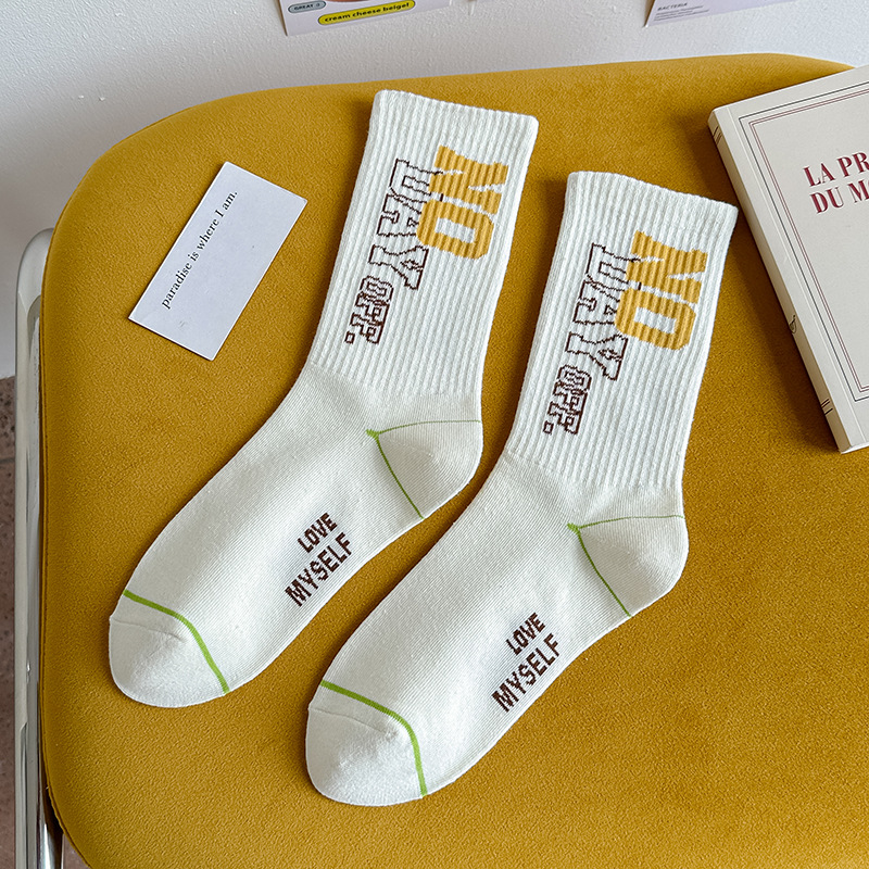 Calcetines de algodón de color puro Mediados de la pantorrilla de las mujeres Otoño e invierno Letras blancas Calcetines de marea de alta elástico Calcetines deportivos al por mayor