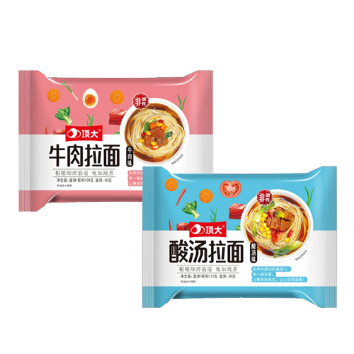 A large bag of hot red oil cold noodles with a topping of sesame paste, a bag of instant spicy sour noodles for easy consumption, convenient ready-to-eat food.