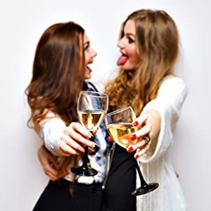 two girls holding glasses of wine and looking at the camera