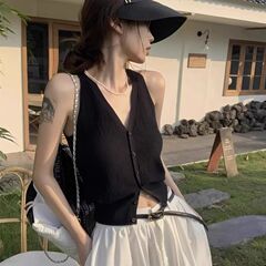 黒いvネックの中にニットのキャミソールを掛けています。