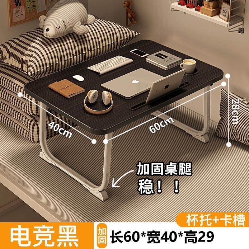 ベッドの上の小さい机のノートパソコンの机の上で折り畳みます。|undefined
