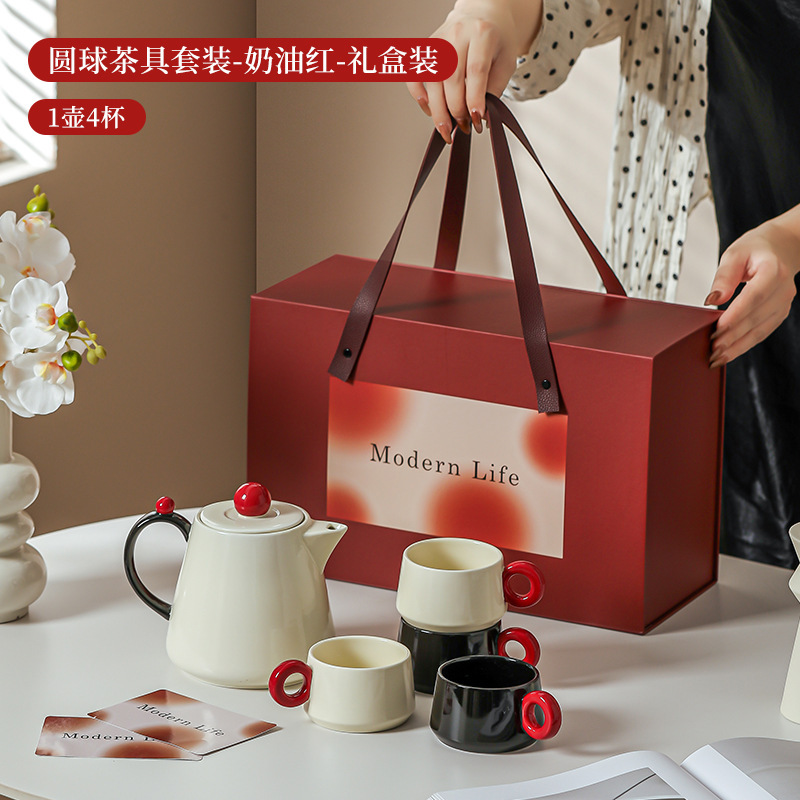 La ama de casa moderna es la misma creativa encantadora de alto valor de la cara con un conjunto de utensilios de agua de cerámica doméstica para invitados con un conjunto completo de tetera de té