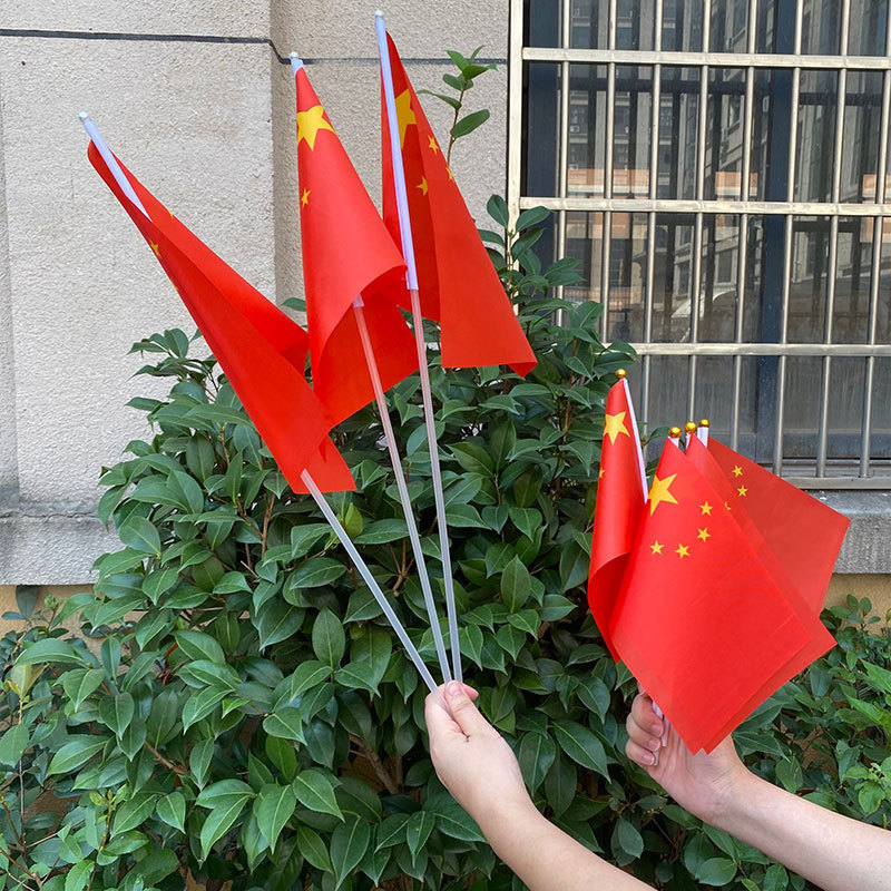 光る党の旗の国旗の国慶節の手は光る国旗を振って手を持ってハンドルの小さい紅旗の贈り物をたたきます。|undefined